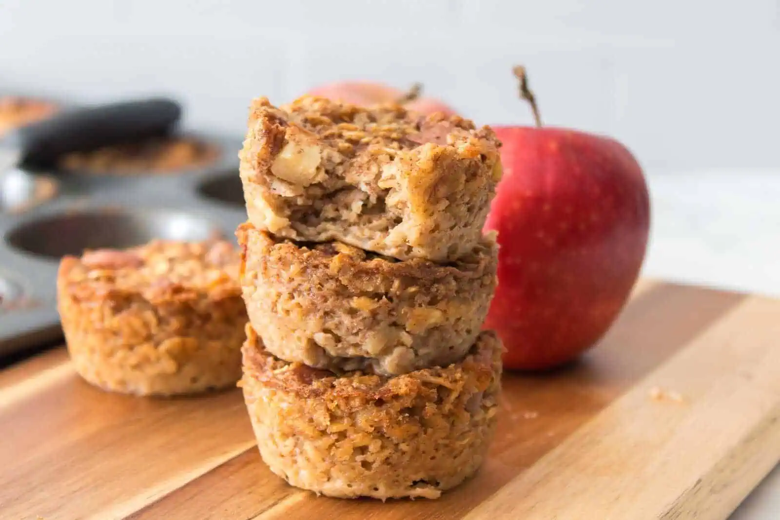 Homemade apple cinnamon oatmeal cookies with fresh red apple in the background