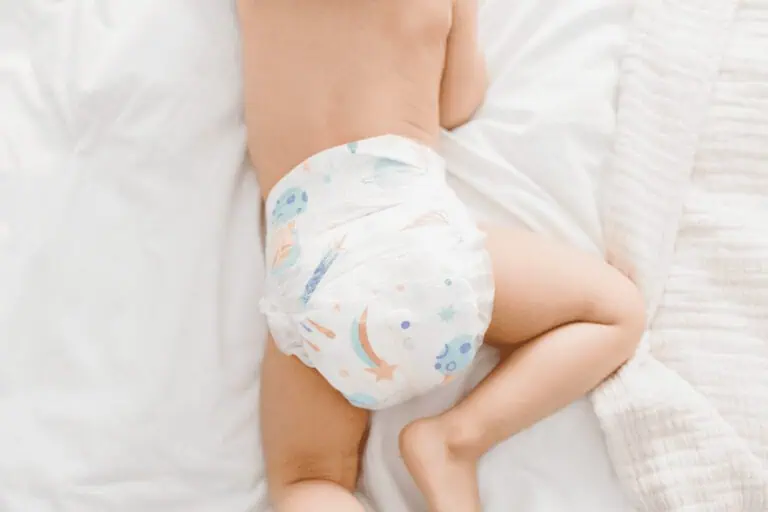 Soft baby in diaper resting on white bed, adorable infant, newborn, cozy nursery environment, family concept.