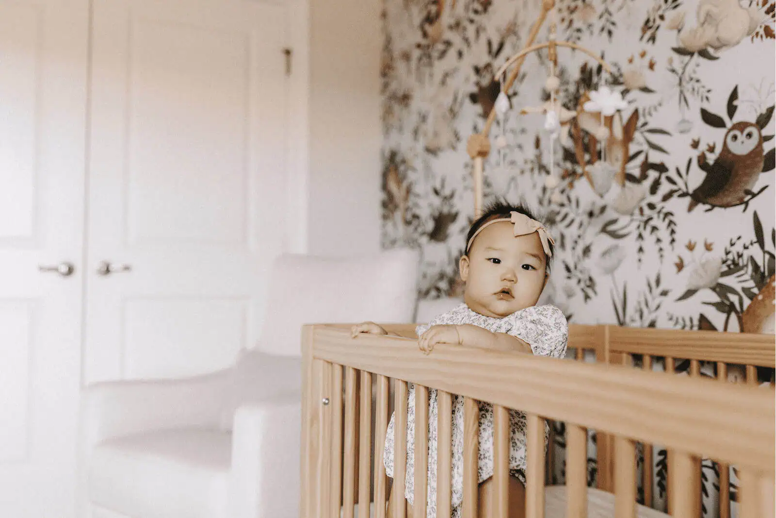 Beautiful Asian baby girl in a crib at a surrogacy family home, evoking happiness, care, and family love.