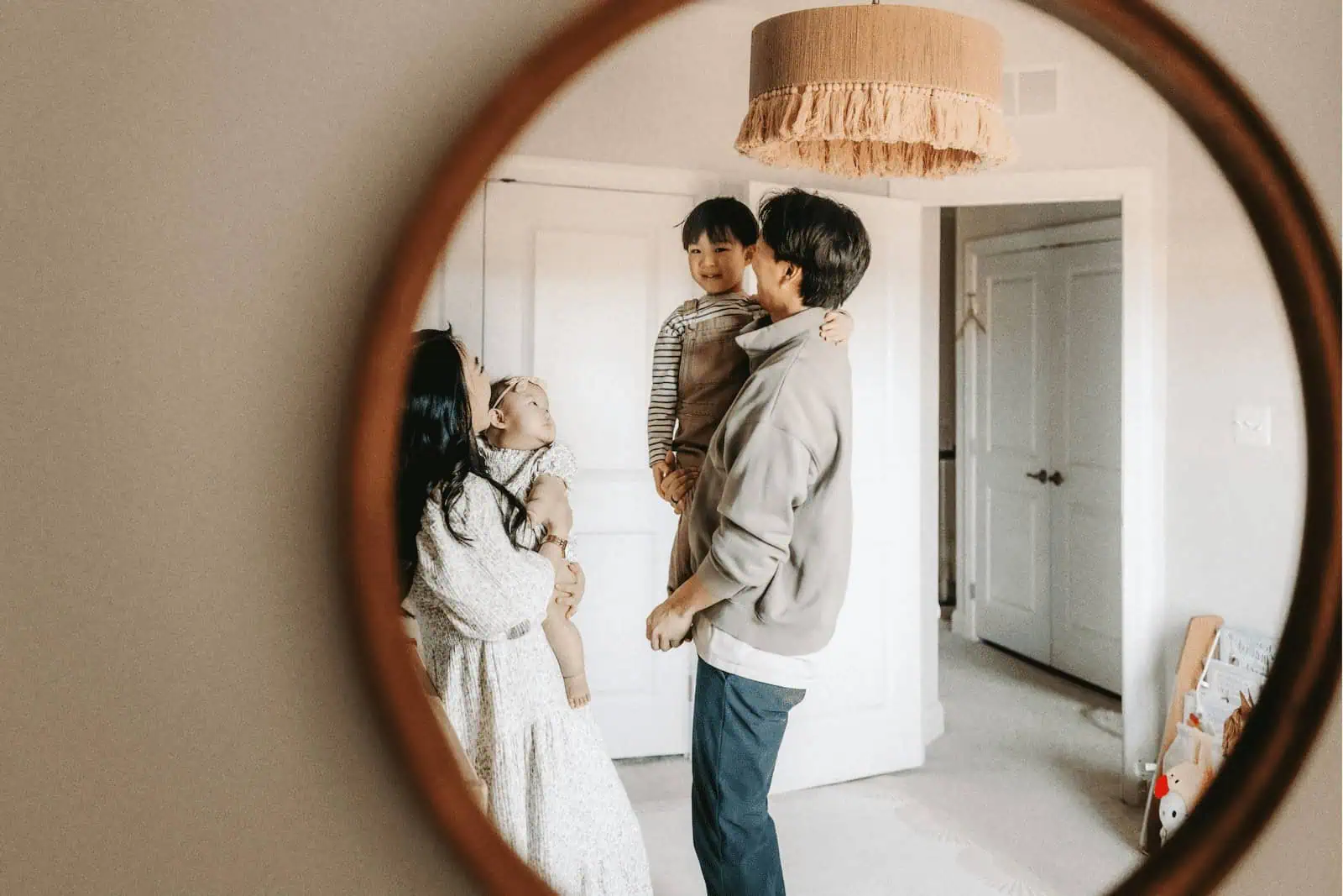 Joyful family moment with children reflected in home mirror, representing surrogacy and family building.