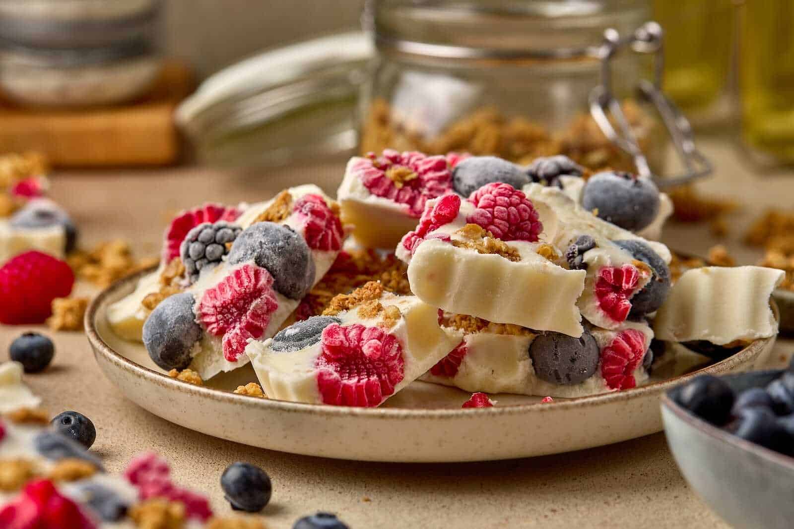 Healthy and delicious berries yogurt bark topped with fresh raspberries, blueberries, and crunchy granola, perfect for desserts or snacks.