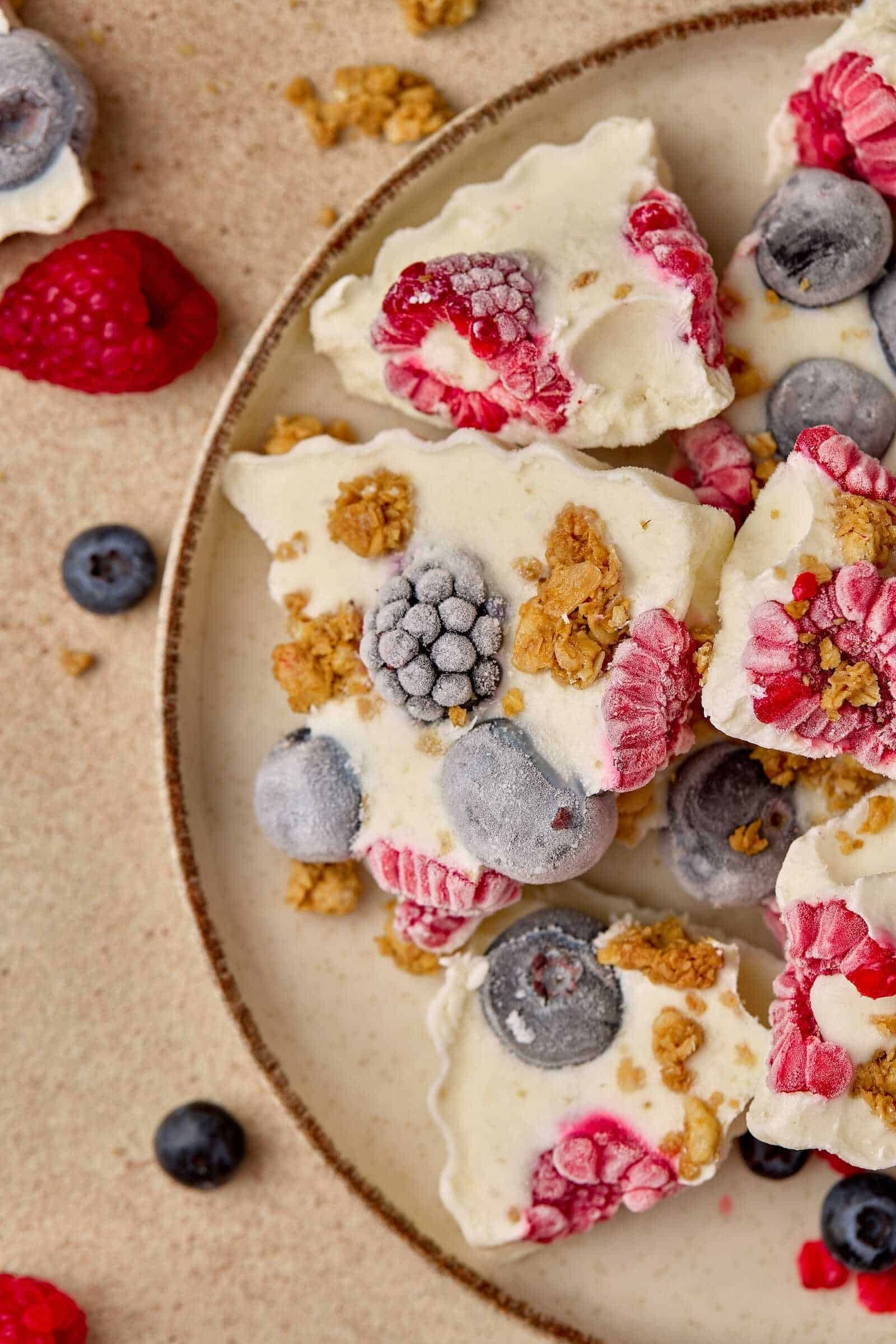 Delicious frozen yogurt bark topped with fresh berries and crunchy granola, perfect for a healthy treat.