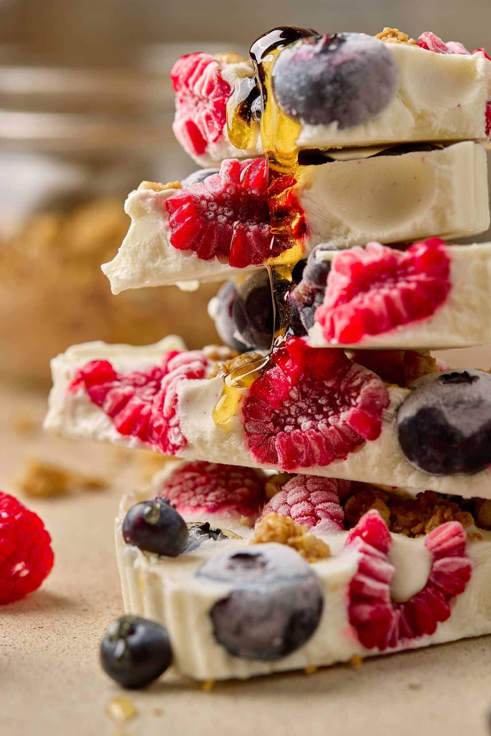 Delicious berry white chocolate bark with fresh raspberries and blueberries, drizzled with honey for a sweet treat.