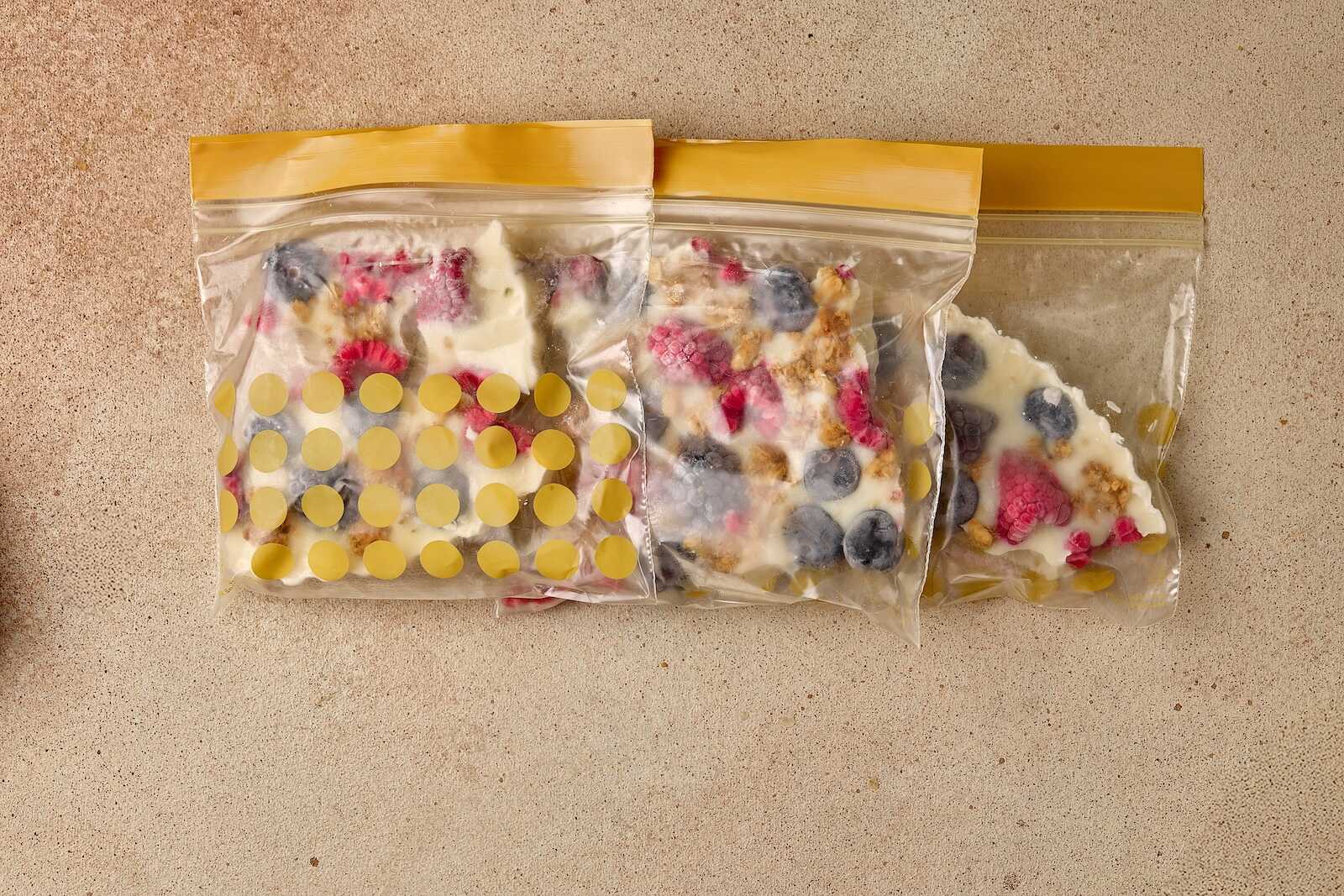 Resealable bags filled with frozen berries and yogurt for healthy snacking and smoothies.