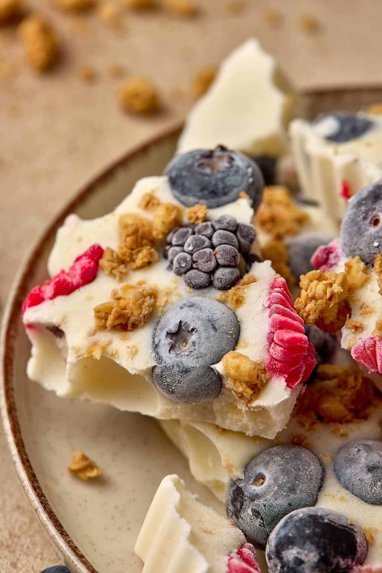 Delicious frozen yogurt bark with blueberries, raspberries, and granola topping. Perfect healthy dessert or snack.