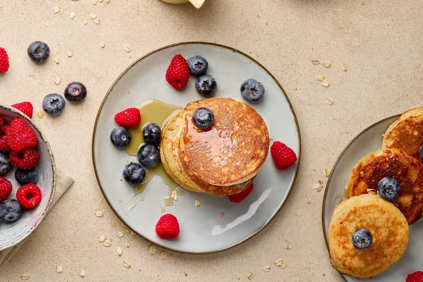 Delicious blueberry pancakes topped with fresh berries and syrup for breakfast.