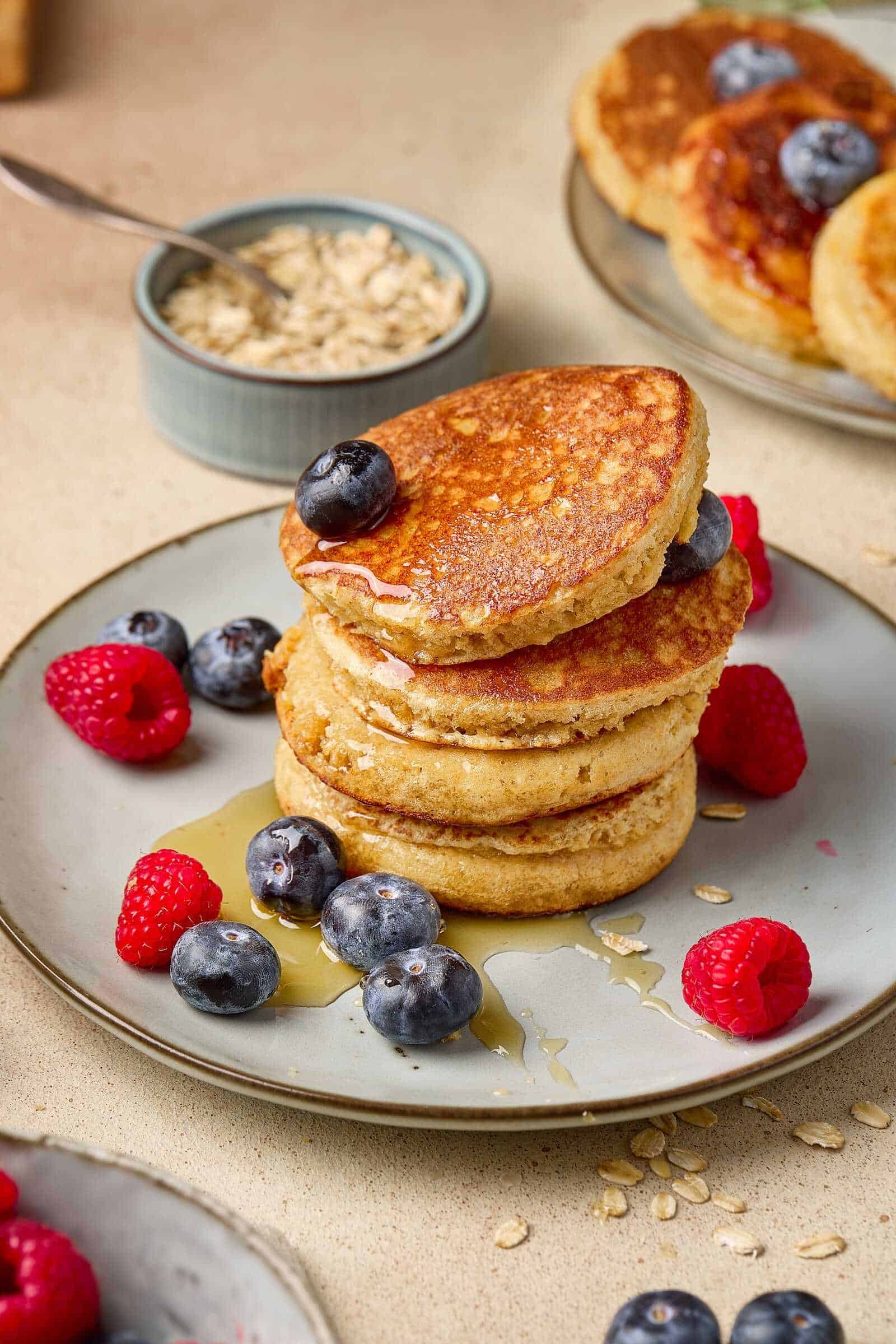 Delicious stack of homemade blueberry pancakes topped with fresh blueberries and syrup.