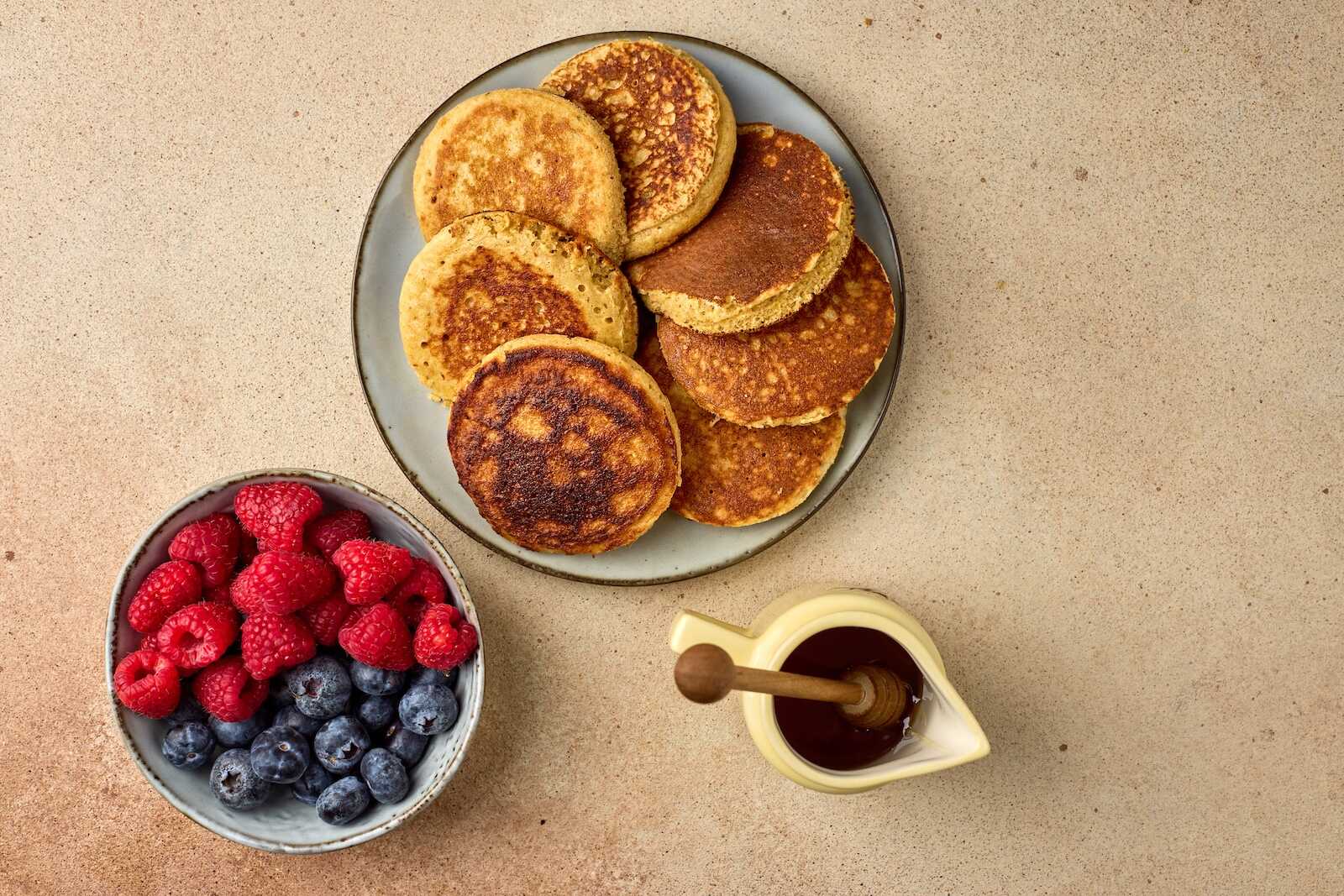 Delicious homemade buttermilk pancakes served with fresh raspberries and blueberries, topped with syrup. Perfect breakfast treat.