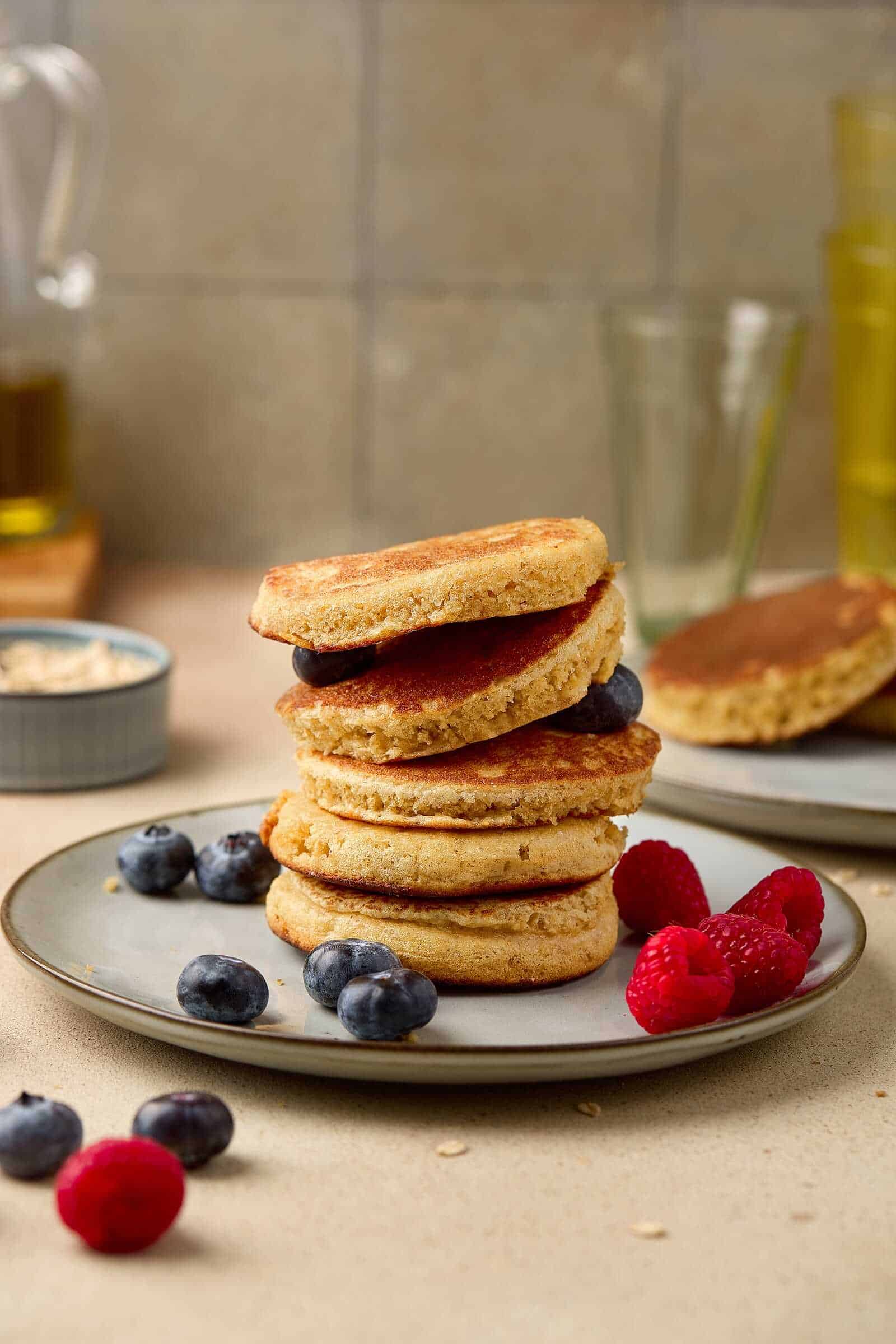 Delicious homemade pancakes topped with fresh blueberries and raspberries, perfect for a cozy breakfast.