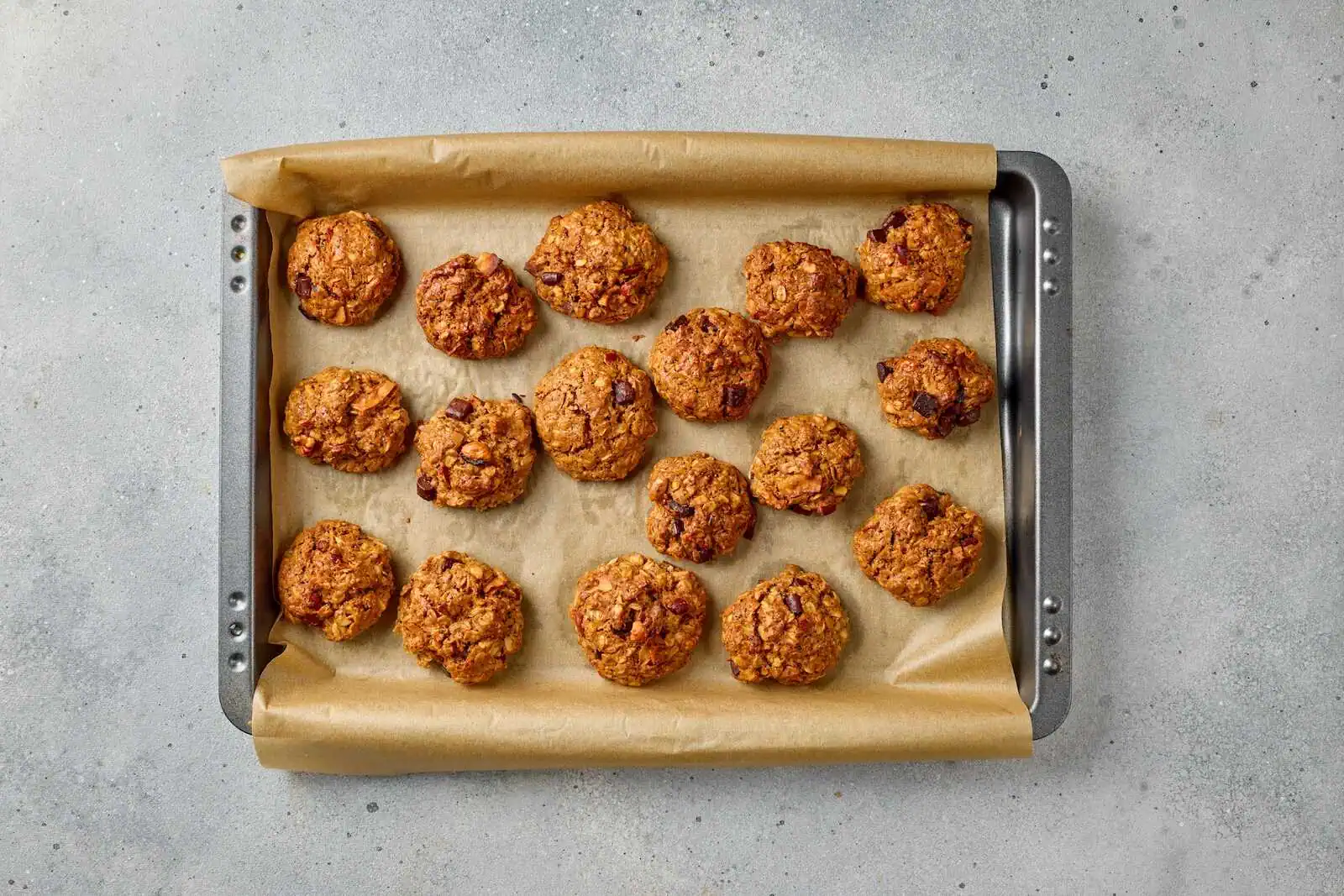 Delicious oatmeal chocolate chip cookies freshly baked on parchment paper for snacking.